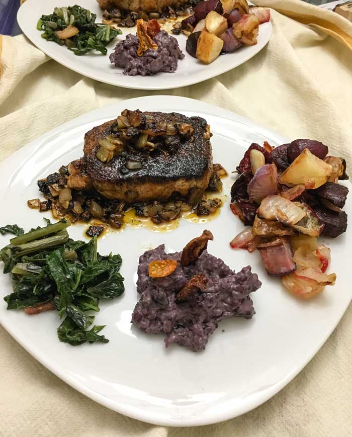 Pork chops with caramelized onions, roasted root veggies, braised rutabaga leaves, and creamed black Incan corn with sun-dried tomatoes. 