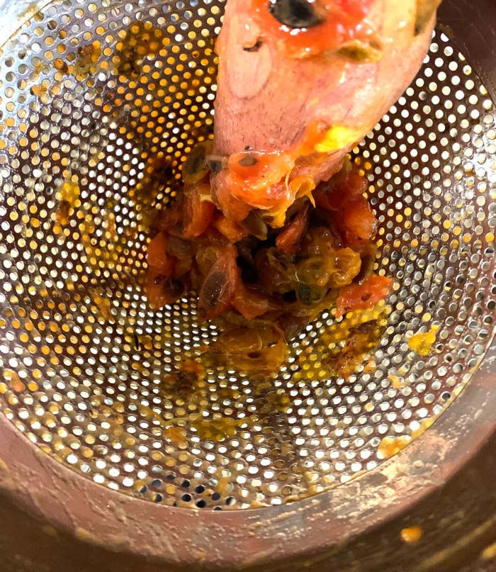 American persimmon seeds left at the bottom of a chinois strainer. The pulp goes into a bowl placed under the strainer. Use a spatula to scrape off all the persimmon pulp from the outside of the strainer!