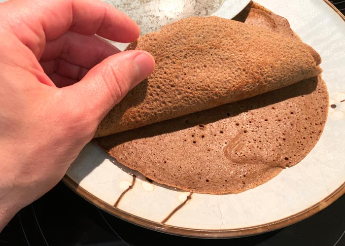 Starting to stack acorn flour crepes in their covered dish - here you can see they have an ideal crepe texture.