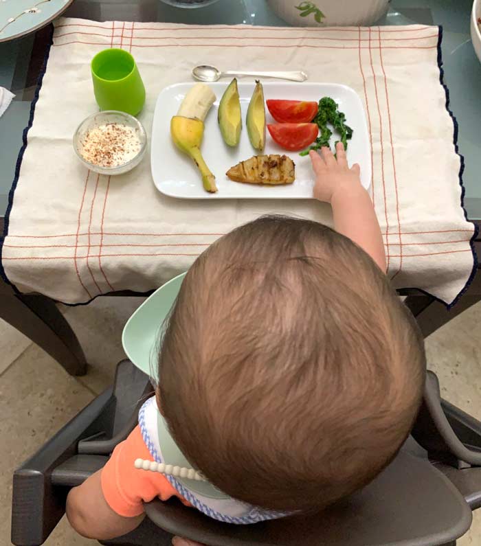 Baby-led weaning: baby eating vegetables. 