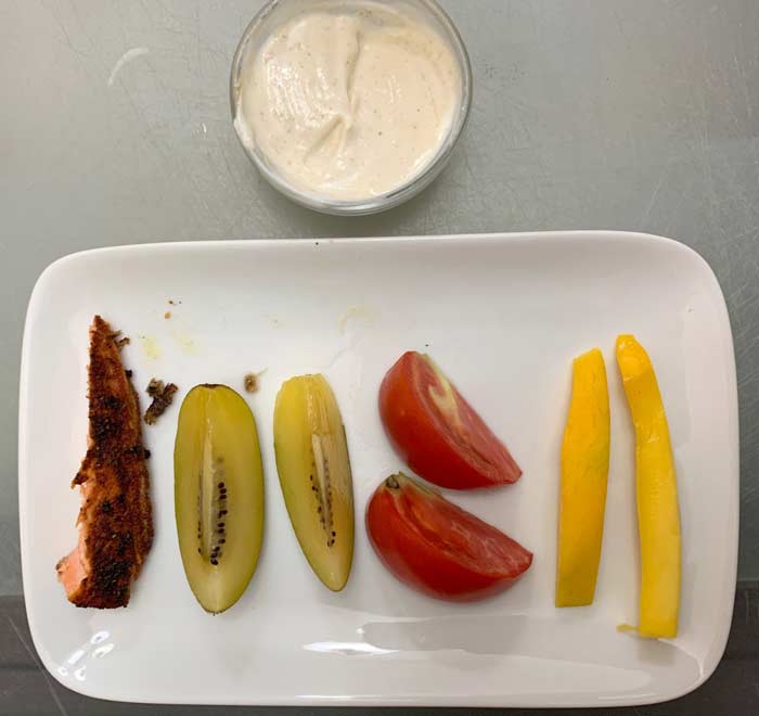 From top: a) goat yogurt with almond butter, b) salmon, c) kiwi slices, d) garden-ripe tomatoes, e) mango slices. 