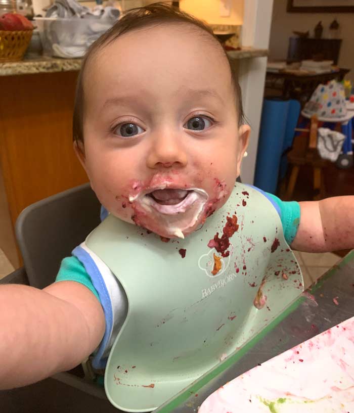 Who wouldn't want to kiss that face? Baby-led weaning is a humorously messy affair.