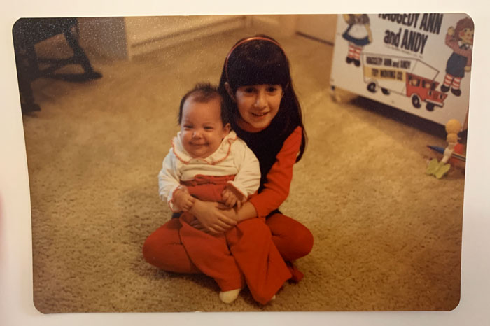 Kids being kids. Baby sister Susan being welcomed into her adopted home by big sis Lisa a few decades ago.