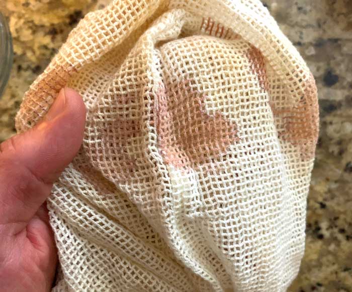 Our white linen mushroom harvesting bag featuring the red stains of a beefsteak mushroom.
