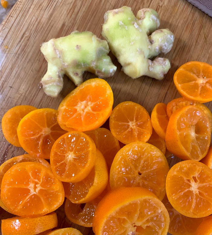 Sliced and de-seeded calamondins (in front) and peeled baby ginger in back, ready to be grated.