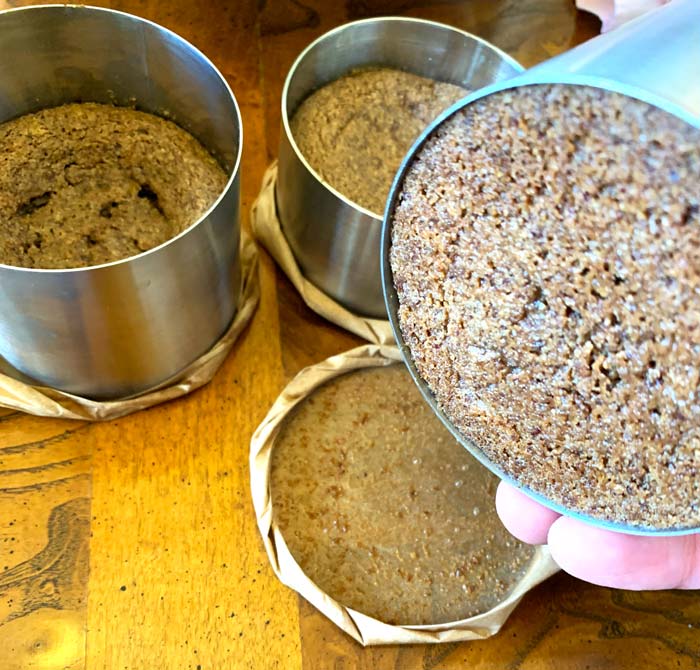 On the right, you can see the bottom of a baked crumble cake in the ring mold plus the parchment paper wrap used while baking. 