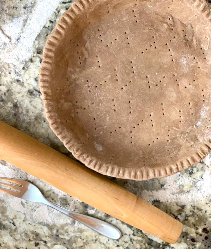 Little tip to save you some heartache: punch holes in the crust prior to pre-baking it. This will let steam escape thus preventing your crust from bubbling and deforming. 