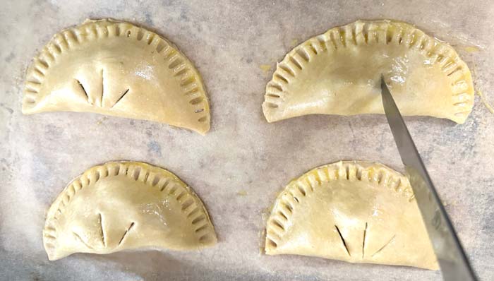 We cut a longer center line and two smaller side lines when scoring our crabapple hand pies. this isn't just decorative - it allows steam to escape thus keeps them from exploding during baking.