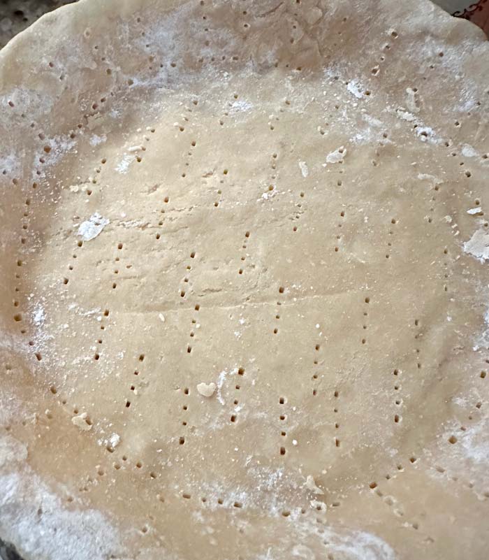 Docked pie crust ready to be chilled.
