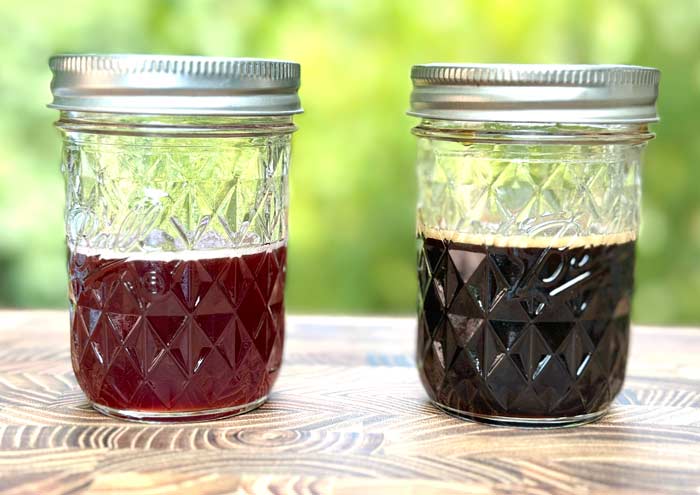 Two different finished batches of fermented elderberry syrup. The bubbles on top are due to beneficial microbial activity, aka probiotics.