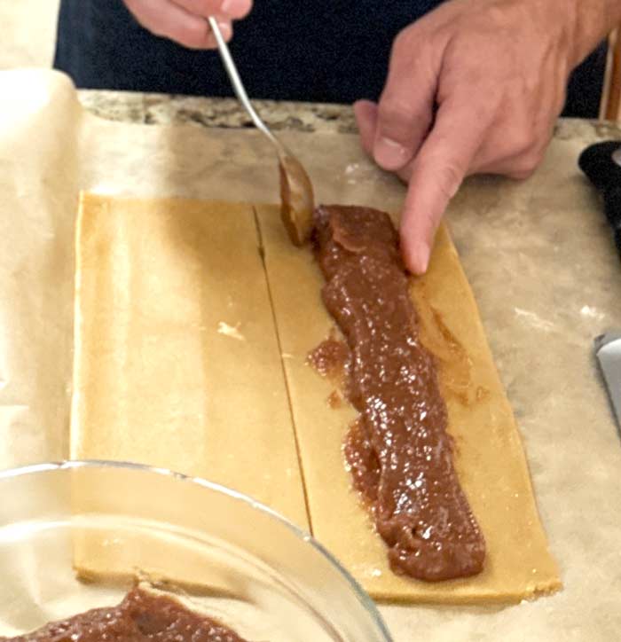 Fig filling going into the dough strips.