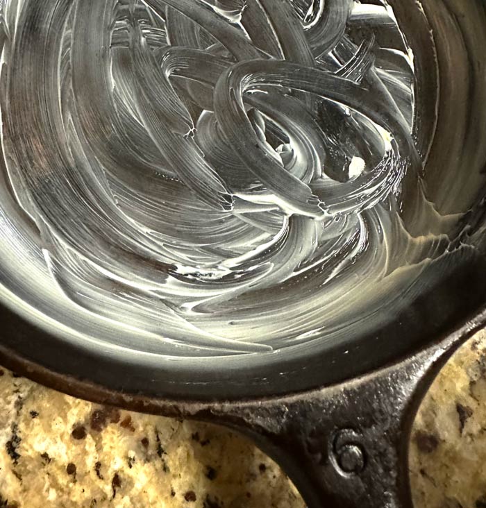 Well-buttered pan ready for smashed ground cherries.