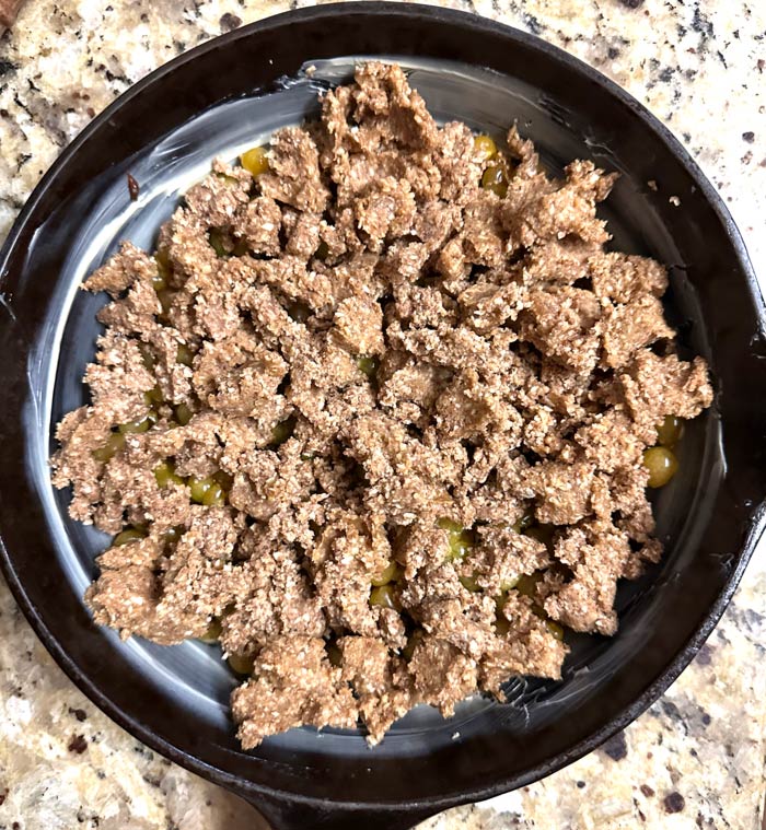 Break the crumble dough into small bits by hand, then evenly distribute it over the surface of the ground cherries.