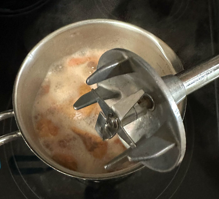The blade attachment on an immersion blender will quickly puree cooked guava pulp without pulverizing the hard seeds.