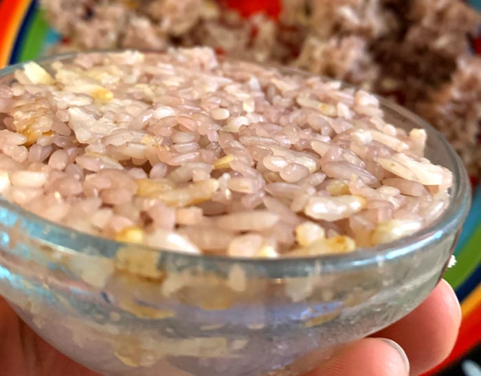 Using a small bowl to prepare a portion of steamed rice for plating.