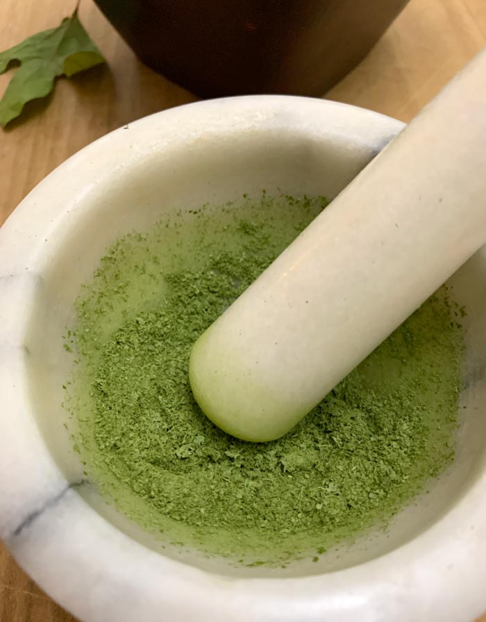 Final steps: grinding the leaves into filé powder with a mortar and pestle. 