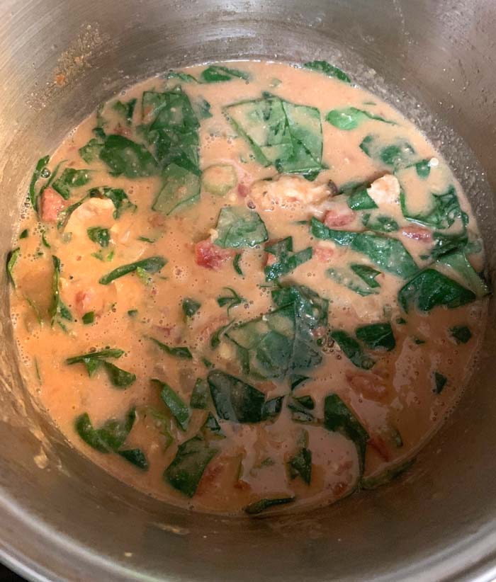 Malabar spinach recipe: A large pot of groundnut stew with Malabar spinach just added and starting to wilt. If you're looking for a delicious recipe for Malabar spinach, you're in the right place!