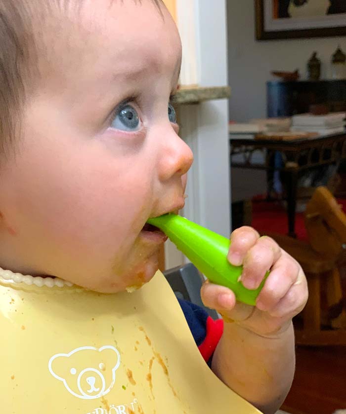 Like father, like son. Sebastian enjoying putting groundnut stew with Malabar spinach on his bib, face, arms, floor, walls... and some in his mouth. 