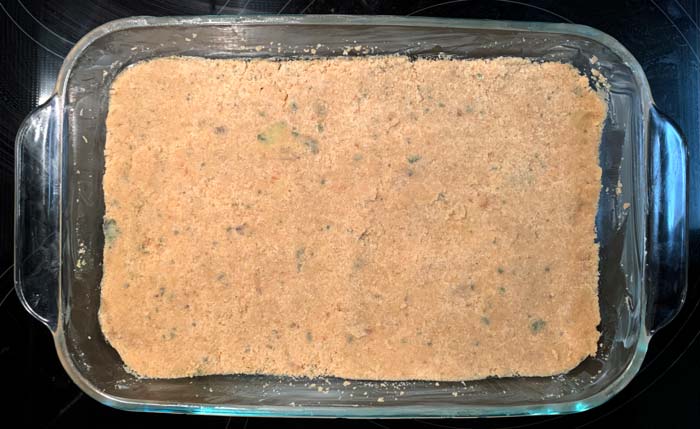 Evenly and firmly press the shortbread dough into place in your buttered baking dish using your hands or a firm spatula.