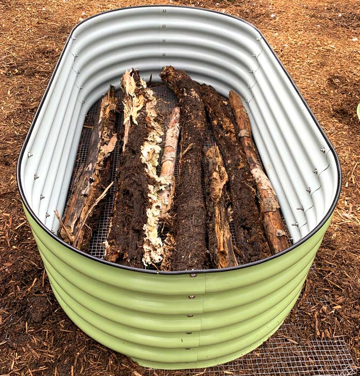 Heavily decomposed logs form the foundation of our new raised beds.