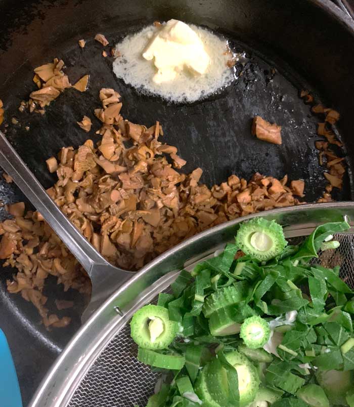 Flash-boiled milkweed about to hit the pan with cooked chanterelles.