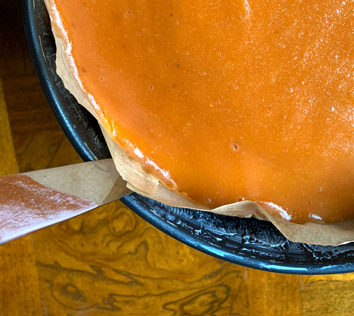 Use a butter knife to loosen the parchment paper from the sides of the spring form pan.