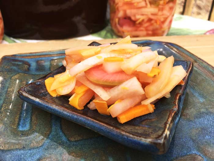 Beautiful, colorful, crunchy, and delicious. Pickled daikon radishes with turmeric and ginger also happen to be an amazing probiotic food that's awesome for your health.