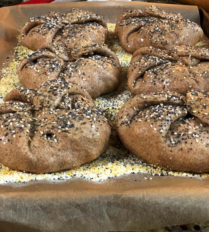 Place each finished poğaça onto a cookie sheet that has a thin layer of cornmeal on it. The cornmeal keeps the poğaças from sticking to the sheet or to the spatula as you're transferring them into your wood-fired oven. If you're using a conventional oven, you don't have to use cornmeal. Instead, just put your poğaças straight on to your cookie sheet or parchment paper before baking.
