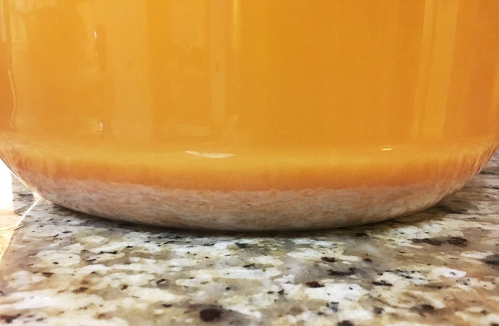You'll want to rack up the mixture a few more times as it ages and continues fermenting to remove as much lees as possible. Lees is the dead yeast and other precipitate that's heavier than the liquid. If you leave the lees in, you'll end up with a cloudy champagne.