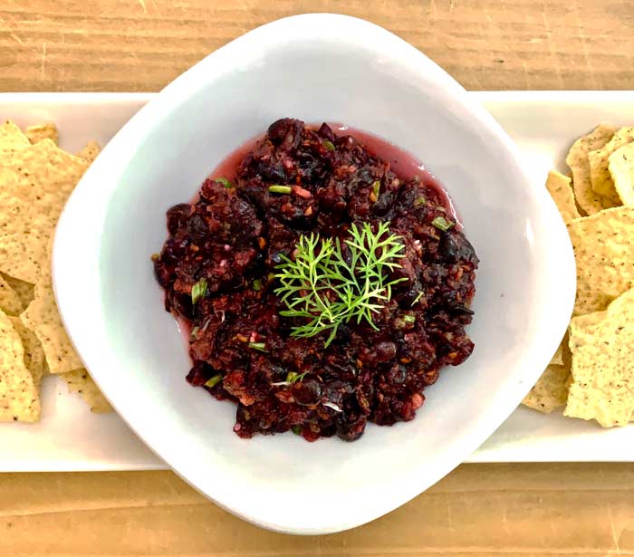 Serviceberry and cilantro berry salsa garnished with the elegant late season leaves of a mature cilantro plant.