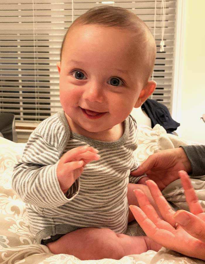 Sebastian smiling and (sitting up!) post-graduation.