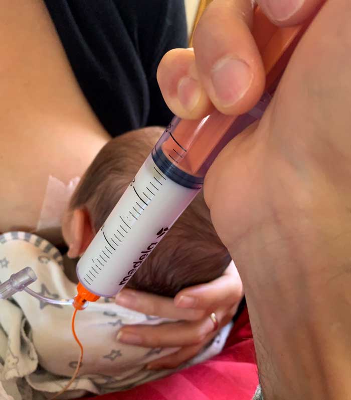 Much of Week 3 was spent stressed and exhausted in moments like this: doing everything we could around the clock to get our baby to take in enough nutrition to gain weight. 